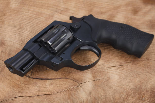 istock Cocked and locked revolver on wooden table 1390728935
