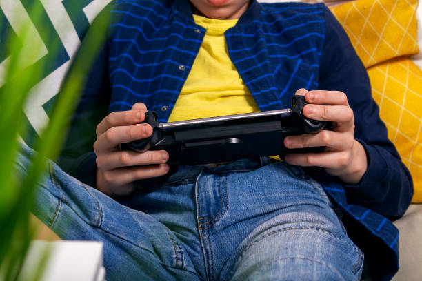 istock Teenager playing on his phone with console 1390744411