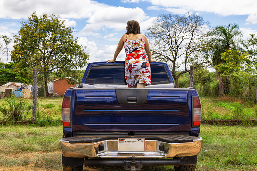 A woman stands on the back of a pick-up truck in Paraguay.