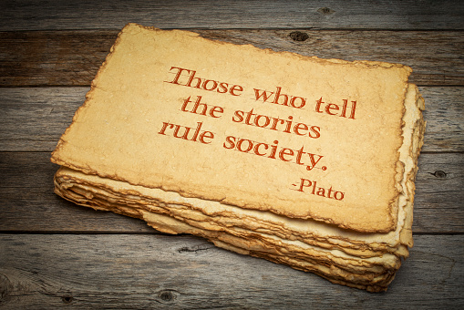 Those who tell the stories rule society, Plato, ancient Greek philosopher, quote. Inspirational handwriting on handmade paper with rough edges against rustic weathered wood, storytelling and narration concept.