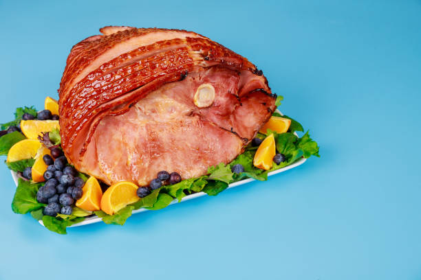 istock Spiral sliced hickory smoked ham with fresh orange and blueberries. 1390772365