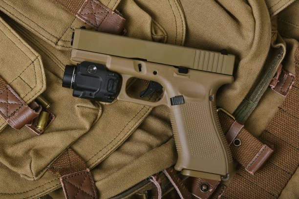 istock Weapons and military gun equipment for army with tactical flashlight, Semi-automatic handgun, 9mm sand color polymer pistol. 1390777230
