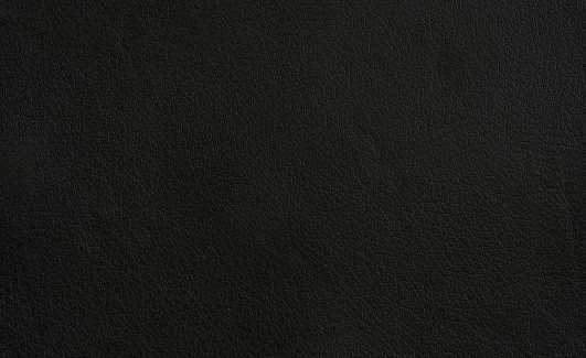 A pattern in a dark plastic as a texture or background.