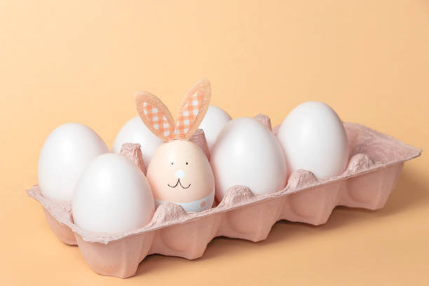 istock The Easter bunny is sitting in a box with white eggs. The concept of approaching the holiday.Festive composition. 1390782149