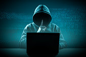 faceless hooded hacker showing silence gesture. Cyber attack, system breaking and malware. Internet crime and electronic banking security. dark digital background