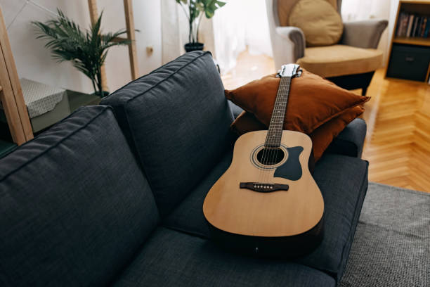 istock Guitar on the sofa waiting to played 1390784259