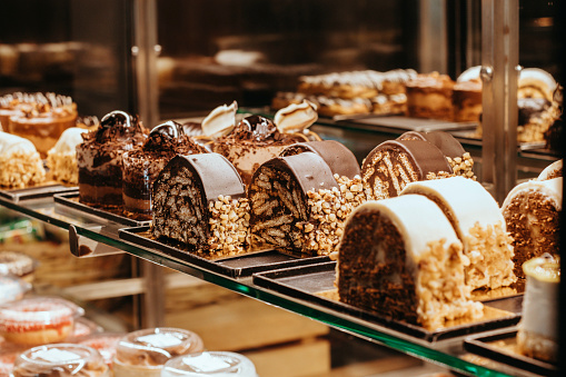 Cake display,Pastry shop glass showcase different types of cakes,Pastry shop display with assorted cakes,Exterior view of the cake on a bakery shelf