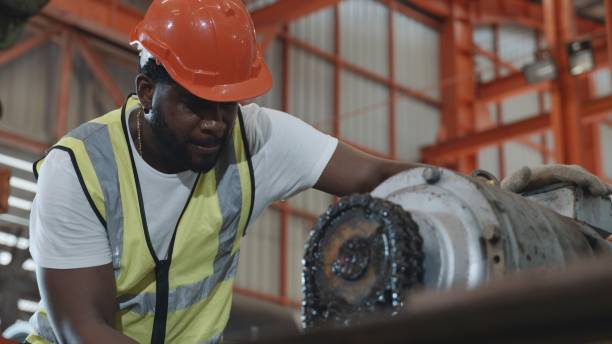 istock Engineer or operator wearing a safety suit maintaining machine in the industrial factory 1390785284