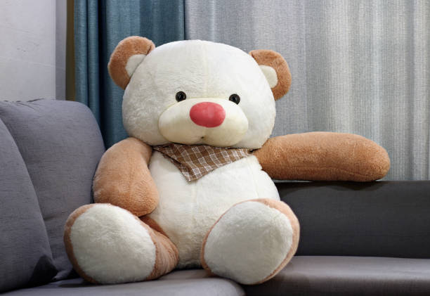 istock Big toy bear doll sitting and relaxing alone on big sofa. 1390786280