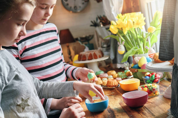 les enfants s’amusent avec de petits gâteaux bundt avec des œufs de pâques et des bonbons - bunt photos et images de collection