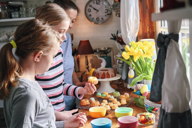 deux filles décorant de petits gâteaux bundt avec des bonbons - bunt photos et images de collection