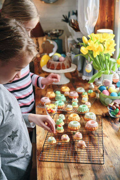 Two Girls Decorating Small Bundt Cakes with Sweets