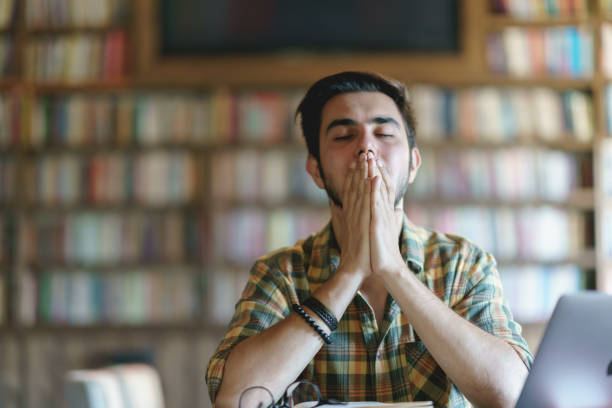 istock Tired Young man at the library 1390788224
