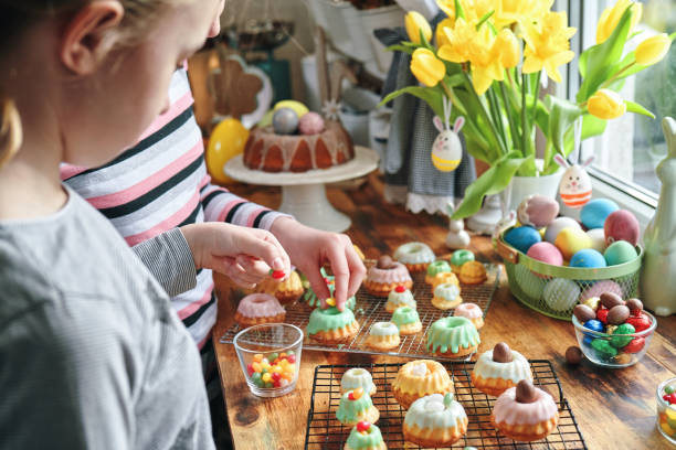 deux filles décorant de petits gâteaux bundt avec des bonbons - bunt photos et images de collection