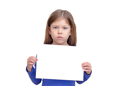 Serious kid holding empty sheet of paper as mock up on white background caucasian little girl of 5 years in blue waist up