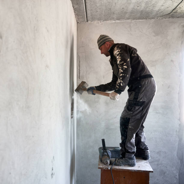 istock Male worker breaking wall with sledgehammer in apartment. 1390791310