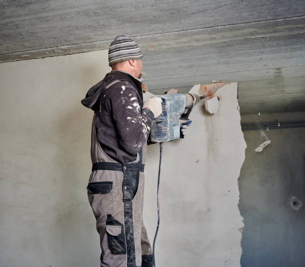 istock Handyman demolishing interior wall in room using perforator. 1390791333