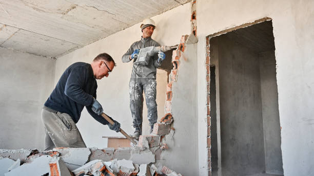 Male workers breaking wall in apartment under renovation. stock photo