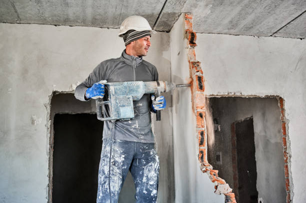 istock Male worker in construction helmet drilling wall with hammer drill. 1390791371