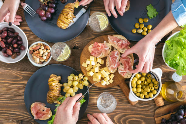 istock Top view of three people having dinner together on rustic wooden table Friends having dinner concept 1390791725
