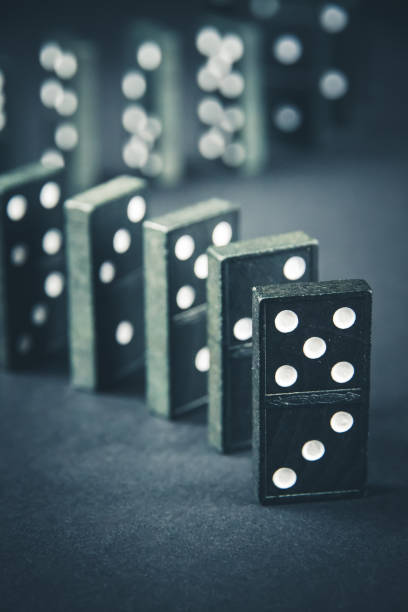 istock Black dominoes chain on dark table background 1390792375