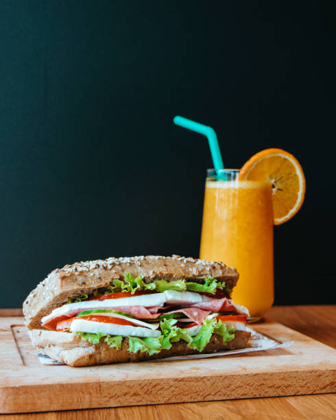 сэндвич с томатным сыром и овощами, сэндвич и свежевыжатый апельсиновый сок на завтрак, сэндвич и апельсиновый сок в кафе - fried egg lettuce vegetable lunch стоковые фото и изображения