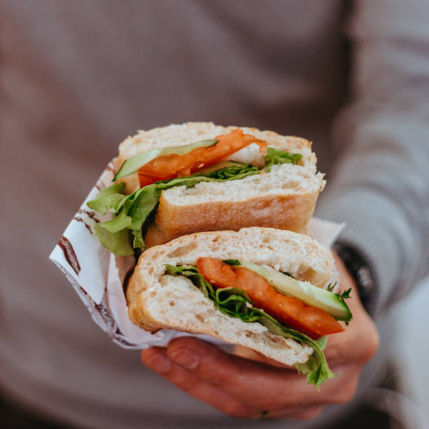 sándwich de desayuno por la mañana, sándwich de tomate de pepino y verduras, persona comiendo sándwich, sándwich de mano humana sosteniendo - sandwich turkey chicken submarine sandwich fotografías e imágenes de stock