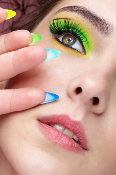istock Young woman with green eyes makeup and multi-colored nails manicure. 1390793370