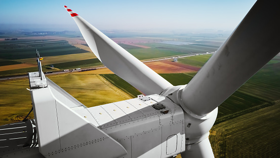 Aerial view of close up windmill turbine in countryside area, Wind power and renewable sustainable energy concept