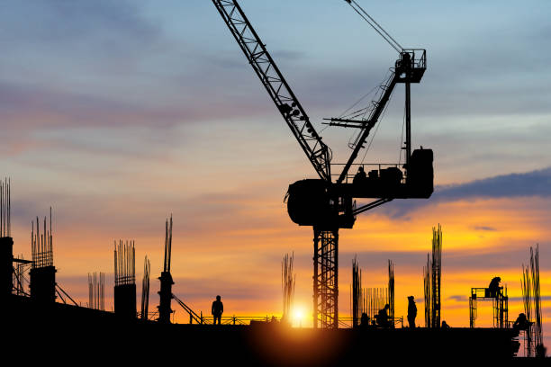 istock Silhouette of worker team on building site, construction site at sunset in evening time 1390795215