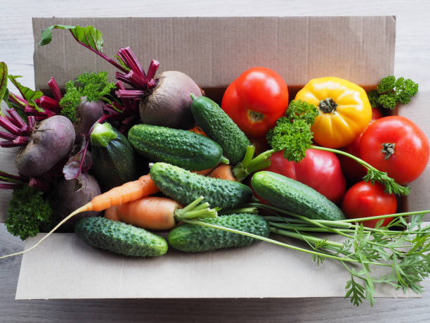 istock Different natural vegetables in a cardboard box, top view. Fresh harvest-yellow and red tomatoes, zucchini, beets, carrots, cucumbers closeup. Gardening and farming. 1390800338