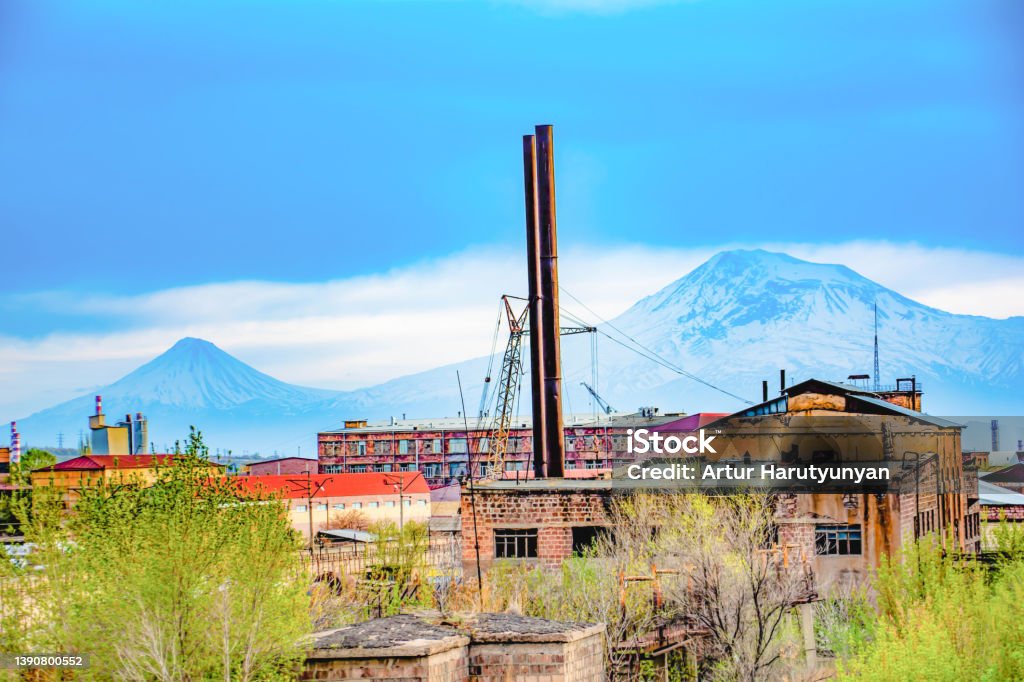 Old Structures And Factory Buildings Against The Backdrop Of Mount