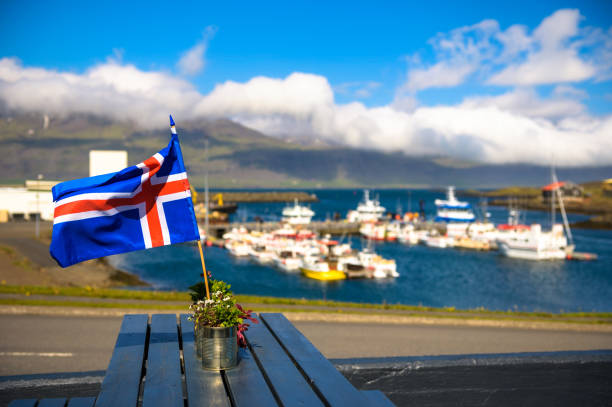 Flag of Iceland placed on a restaurant table with a harbor in the background stock photo