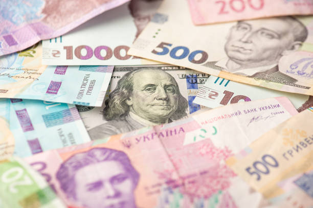 Photo of pile of ukrainian hryvnia banknotes and one hundred dollar banknote in the middle Photo of pile of ukrainian hryvnia banknotes and one hundred dollar banknote in the middle ukrainian currency stock pictures, royalty-free photos & images