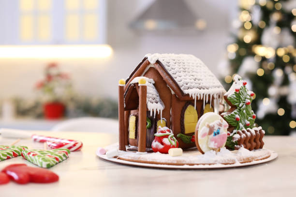 istock Beautiful gingerbread house decorated with icing on white table indoors 1390807839