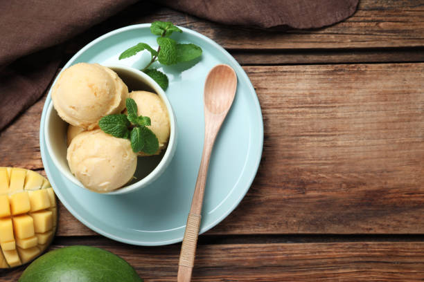 istock Delicious mango ice cream served on wooden table, flat lay. Space for text 1390807975