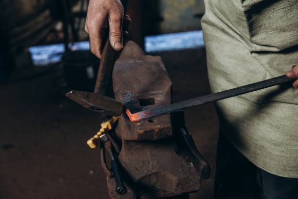 istock The blacksmith manually forging the red-hot metal on the anvil in smithy 1390808985