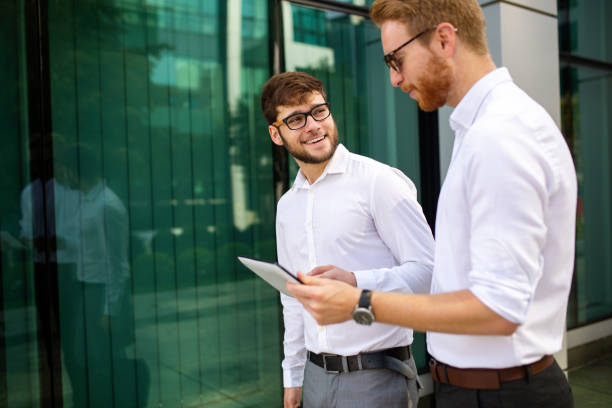 istock Two successful business men walking outdoors. Business, friendship, communication concept 1390809308