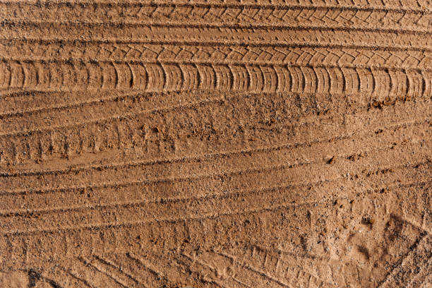 istock Car wheel tracks on dry sand 1390809402