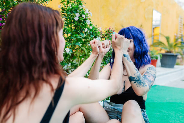 istock Happy young women playing patty cake in backyard 1390810491