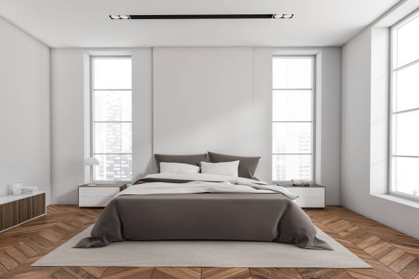 istock Stylish bedroom interior with bed on carpet, panoramic window on city view 1390811476