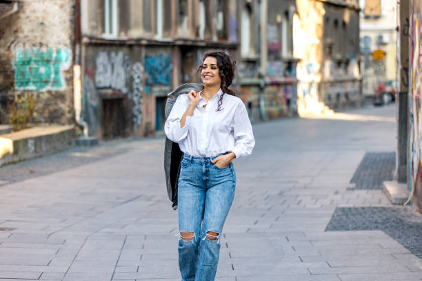istock Woman smiling while walking outdoors on the street. 1390812109