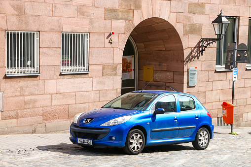Nuremberg, Germany - September 9, 2019: Blue compact car Peugeot 206+ in a city street.