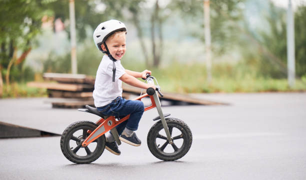 istock Toddler kid learning to ride on run bicycle at skate park. 1390815634