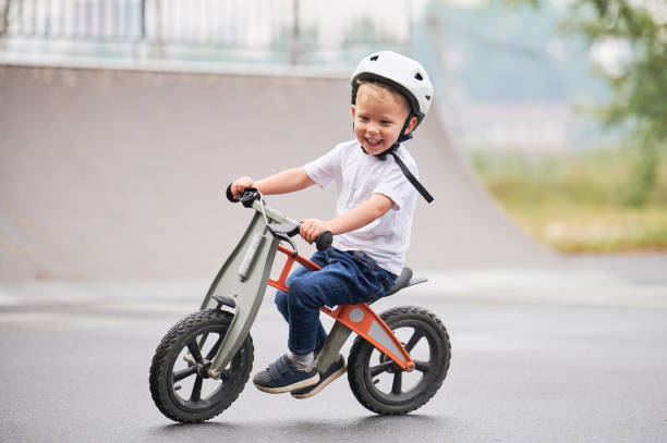 istock Toddler kid learning to ride on run bicycle at skate park. 1390815635