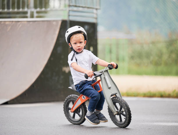 istock Toddler kid learning to ride on run bicycle at skate park. 1390815638