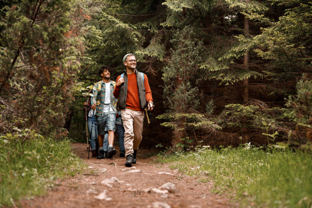 istock Happy male hikers walking through the woods. 1390817266