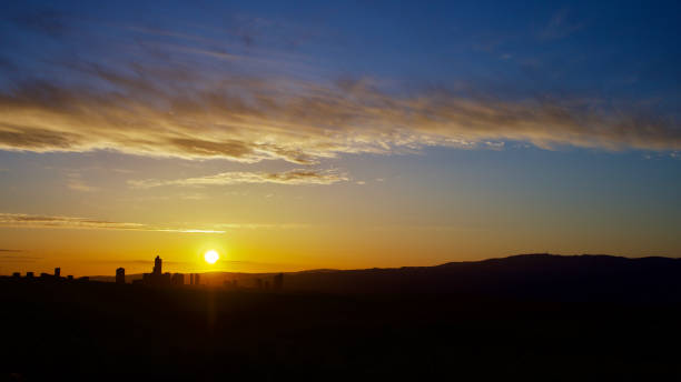 istock Colorful sky and distant city panorama at sunrise. 1390818887