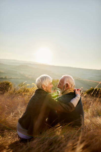 istock Happy senior couple talking during autumn day on a hill. 1390819467