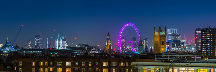 Landmarks of London, from Westminster Abbey, Big Ben, Houses of Parliament, Millennium Wheel to City skyscrapers and The Shard illuminated at night across the rooftops of Chelsea.